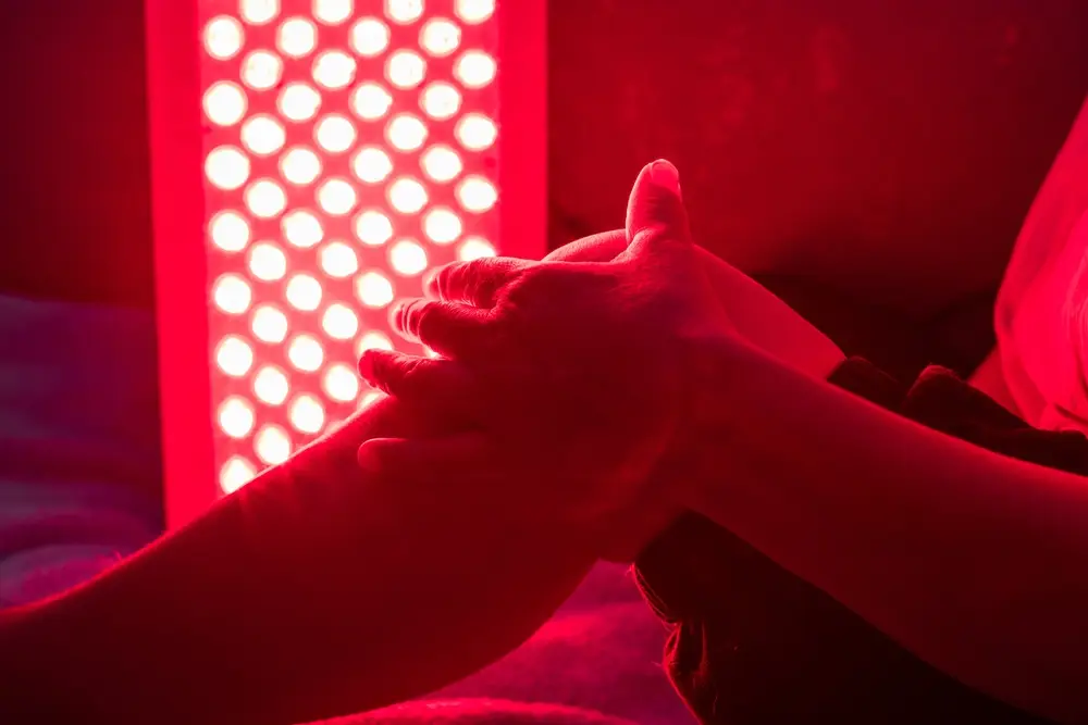 Red light therapy session on a person's hand.